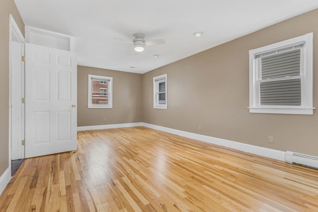 18 School Street, Unit 2 Boston, MA 02119 - Photo 16 of 23 a view of empty room with wooden floor and fan