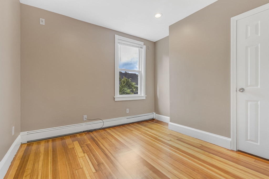 18 School Street, Unit 2 Boston, MA 02119 - Photo 17 of 23 an empty room with wooden floor and windows