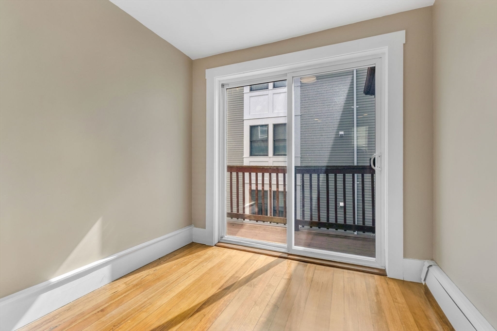 18 School Street, Unit 2 Boston, MA 02119 - Photo 10 of 23 a view of an empty room with wooden floor and a window
