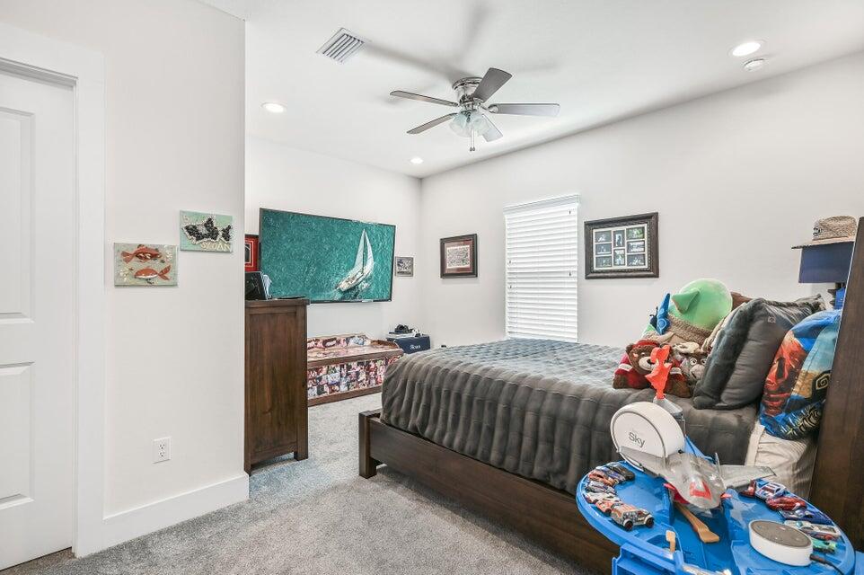 995 Airport Road, Unit 13 Destin, FL 32541 - Photo 22 of 32 a bedroom with a bed and a chandelier
