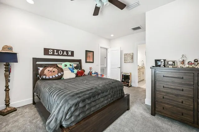 a spacious bedroom with a bed and ceiling fan