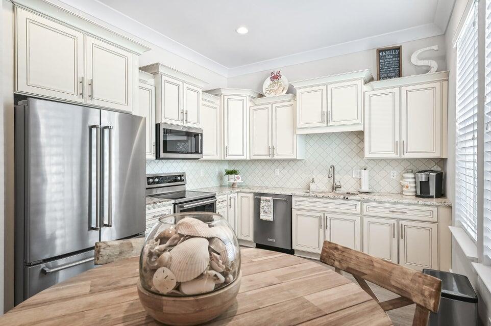 995 Airport Road, Unit 13 Destin, FL 32541 - Photo 9 of 32 a kitchen with a refrigerator sink and cabinets