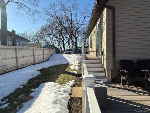 a view of a backyard with wooden fence and large trees