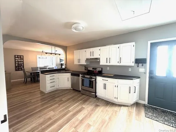 a living room with furniture a dining table and a refrigerator