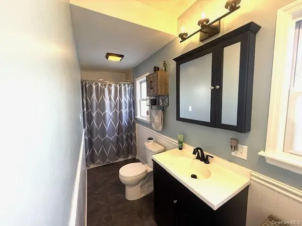 a bathroom with a toilet sink and mirror