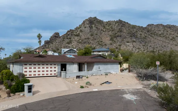 a front view of a house with a yard and mountain view