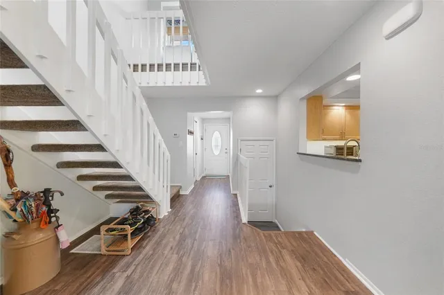 a view of a hallway with wooden floor and stairs
