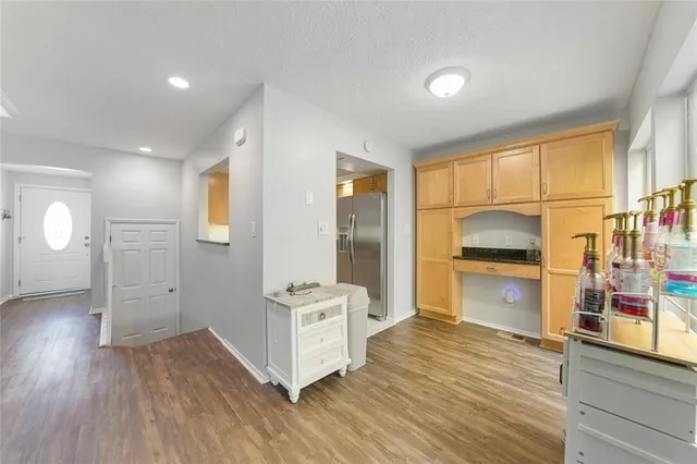 a view of empty room with wooden floor and windows