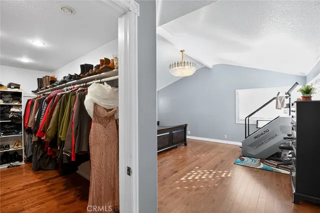 a view of walk in closet with clothes and shoes