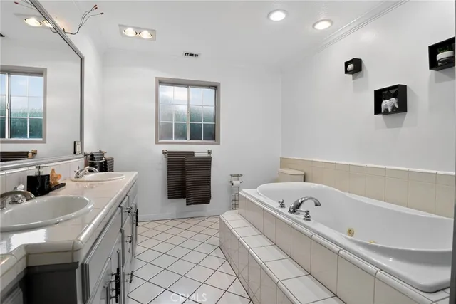 a bathroom with a tub sink and mirror