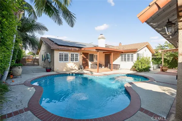 a view of a house with swimming pool and sitting area