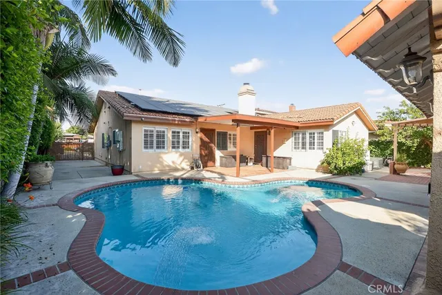 a view of a house with swimming pool and sitting area