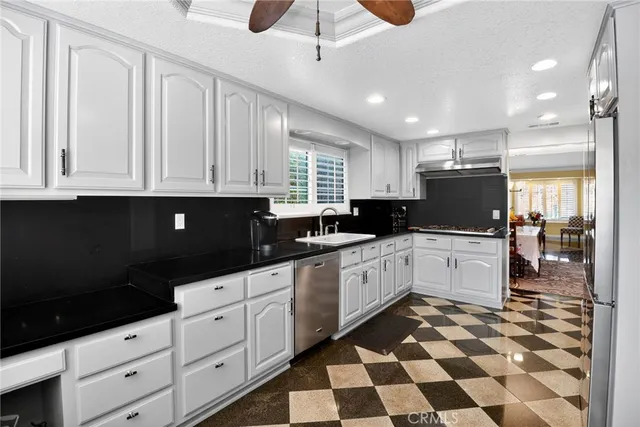 a kitchen with granite countertop white cabinets and black appliances