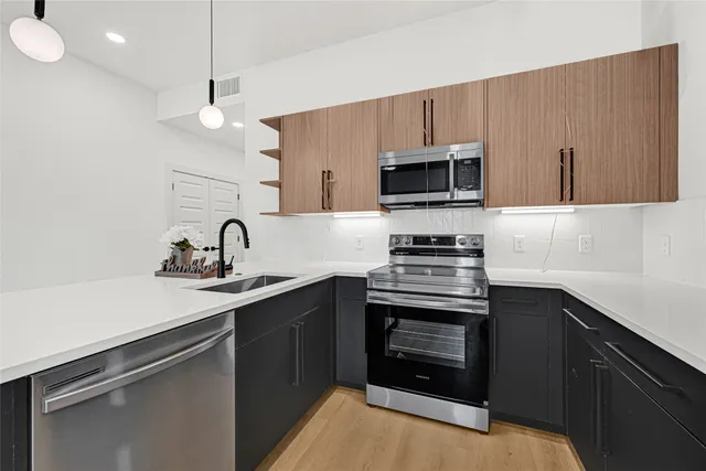 a kitchen with a sink a window and wooden floor