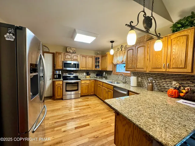 a kitchen with stainless steel appliances granite countertop a sink refrigerator and cabinets
