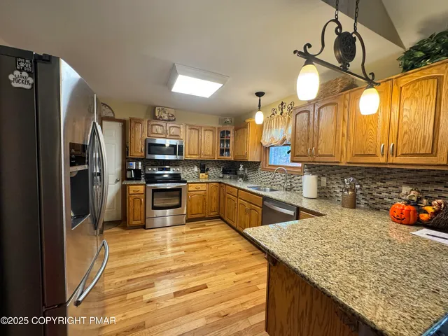 a kitchen with stainless steel appliances granite countertop a sink and refrigerator