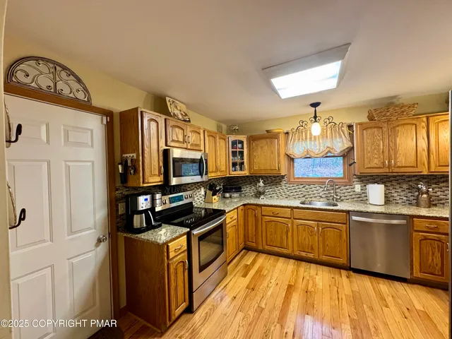 a kitchen with stainless steel appliances granite countertop a sink and stove top oven