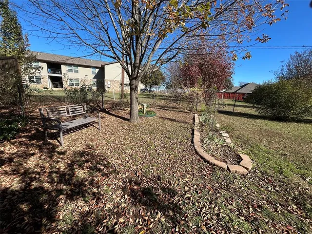 a view of a backyard with wooden fence