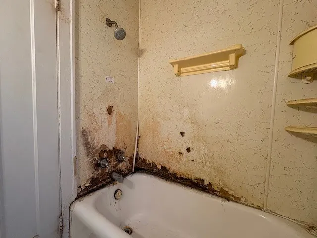 a bathroom with a tub and shower
