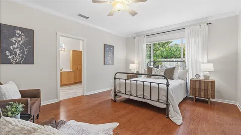 a view of a bedroom with wooden floor and bathroom