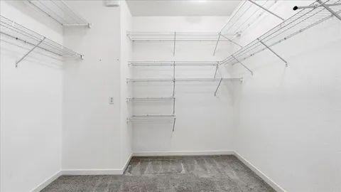 a spacious bedroom with a bed and a ceiling fan