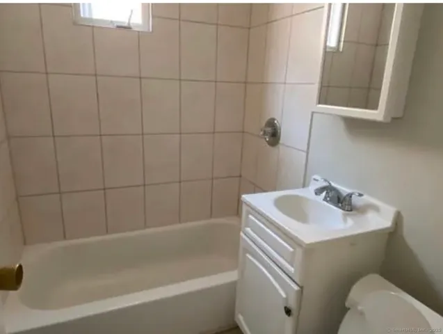a bath tub sitting next to a white sink and toilet