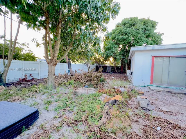 a view of a house with backyard and a trees