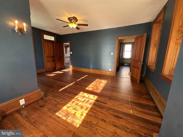 a view of a hallway with wooden floor and a chandelier