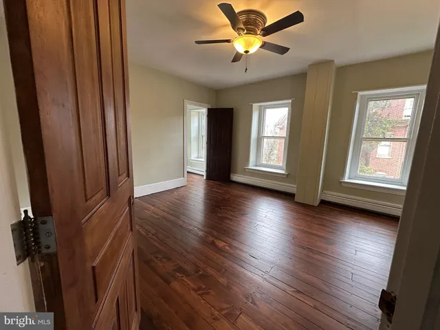 a view of empty room with wooden floor