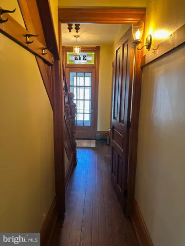 a view of a hallway with wooden floor and staircase