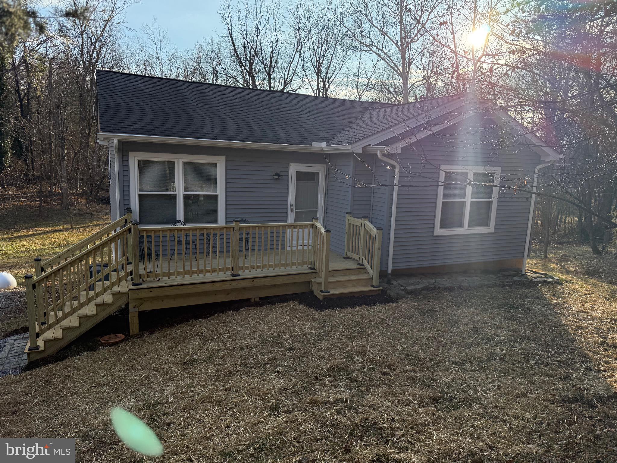 a view of backyard with deck area and wooden fence