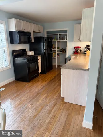a kitchen with granite countertop a refrigerator sink and cabinets