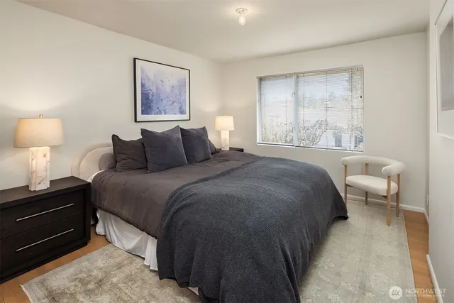 a bedroom with a bed and a lamp on dresser