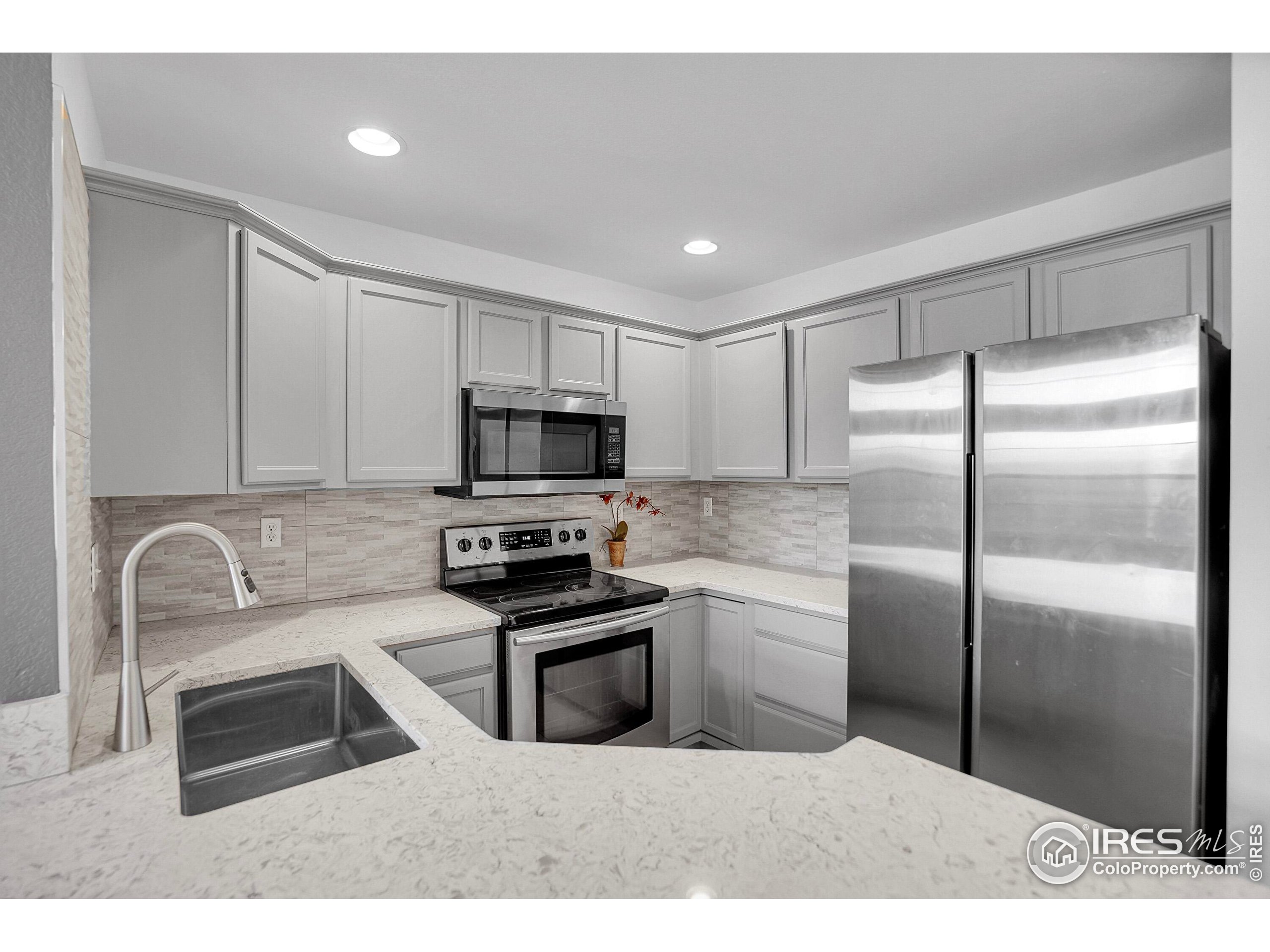 2408 Concord Circle Lafayette, CO 80026 - Photo 17 of 49 a kitchen with stainless steel appliances wooden cabinets a sink and a refrigerator