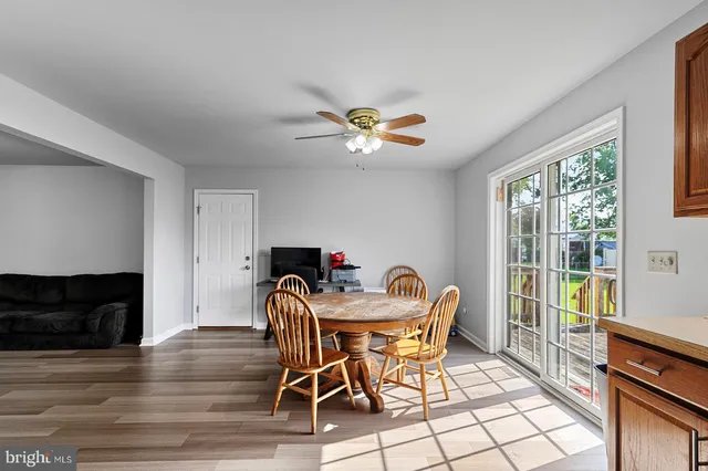 a view of a dining room with furniture a fireplace and wooden floor