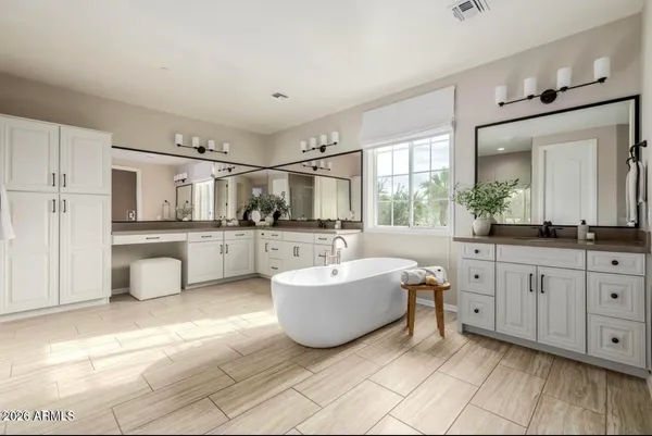 a spacious bathroom with a double vanity sink mirror and bathtub