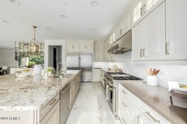 a kitchen with stainless steel appliances granite countertop a sink stove and refrigerator