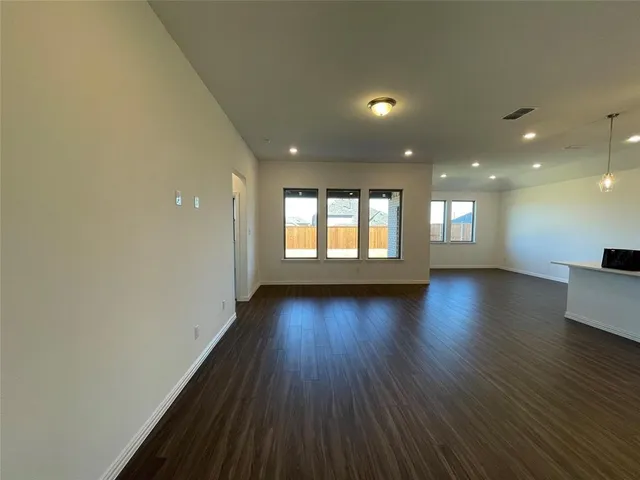 a view of kitchen with kitchen island stainless steel appliances wooden floor and window