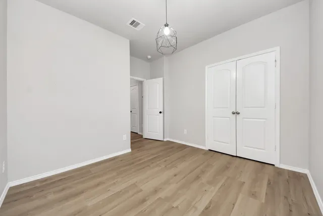 an empty room with wooden floor and mirror