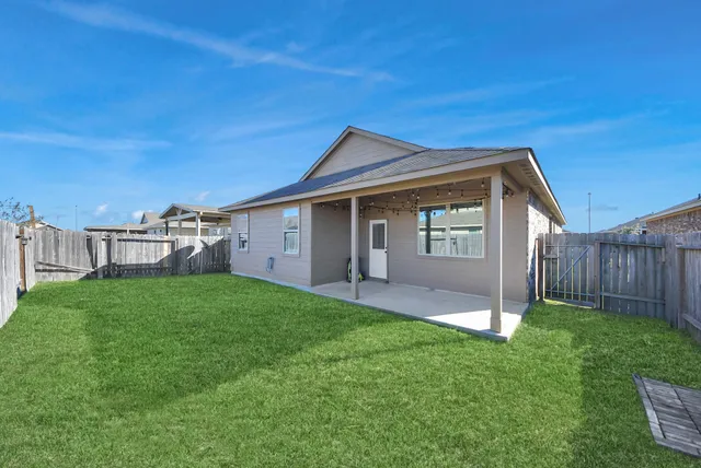 a view of a house with a yard and fence