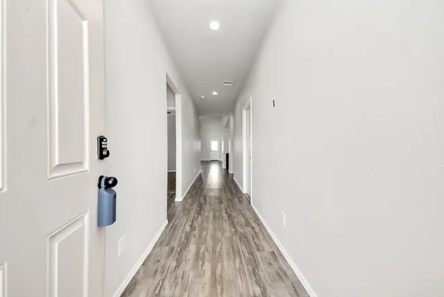 a view of a hallway with wooden floor and staircase
