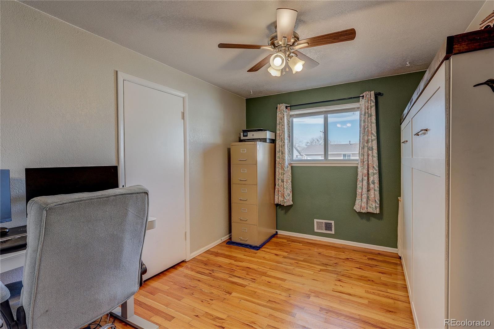 7950 Quebec Street Commerce City, CO 80022 - Photo 16 of 31 a view of a livingroom with wooden floor and a ceiling fan