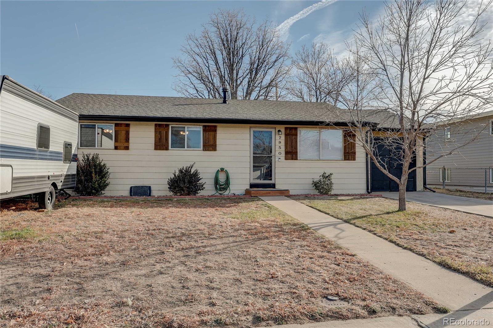 7950 Quebec Street Commerce City, CO 80022 - Photo 2 of 31 a front view of a house with a yard and garage
