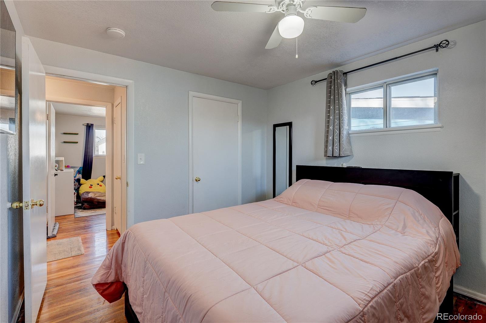 7950 Quebec Street Commerce City, CO 80022 - Photo 22 of 31 a bedroom with a bed and a chandelier