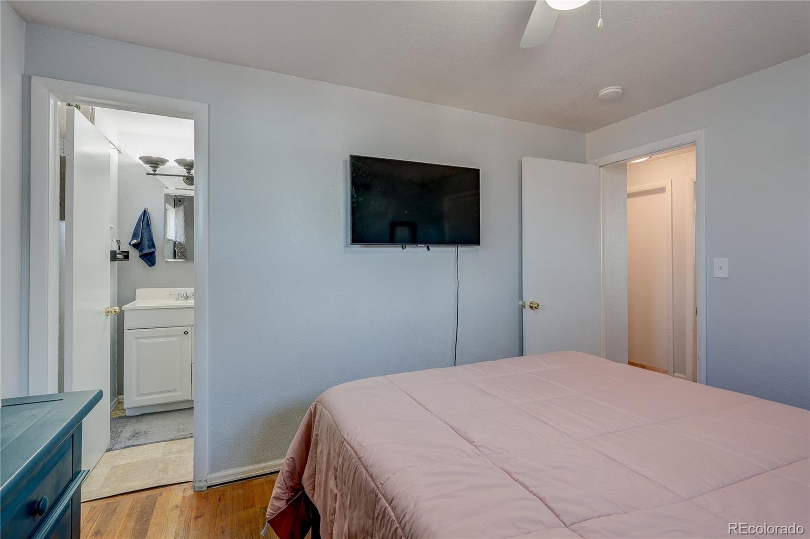 7950 Quebec Street Commerce City, CO 80022 - Photo 23 of 31 a bedroom with a bed and a flat screen tv