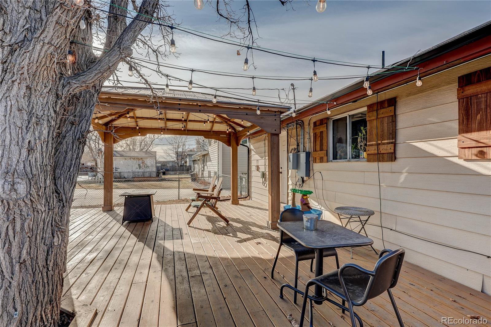 7950 Quebec Street Commerce City, CO 80022 - Photo 27 of 31 a roof deck with table and chairs and wooden floor