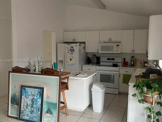 a kitchen with cabinets a stove and a refrigerator