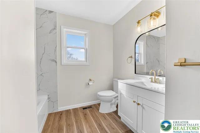 a bathroom with a sink toilet and a mirror