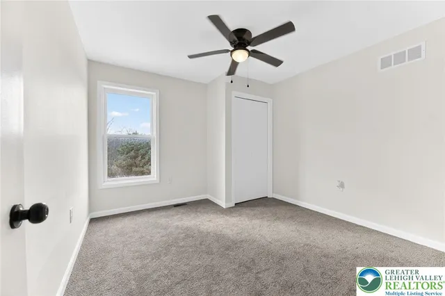 a view of a ceiling fan and a window in a room