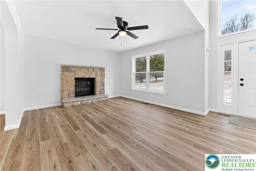 5693 Neola Road Stroudsburg, PA 18360 - Photo 3 of 30 an empty room with wooden floor a ceiling fan and windows